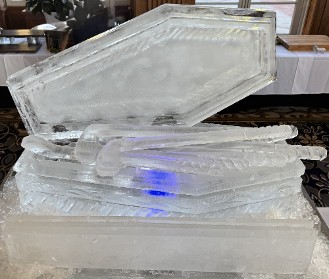 ice matters - open coffin with carved clubs and snowfilled plaque in front