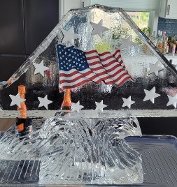 ice matters - double track shot luge - picture of flag frozen into block - snowfilled stars all around - on wave base - single wave bottle holder